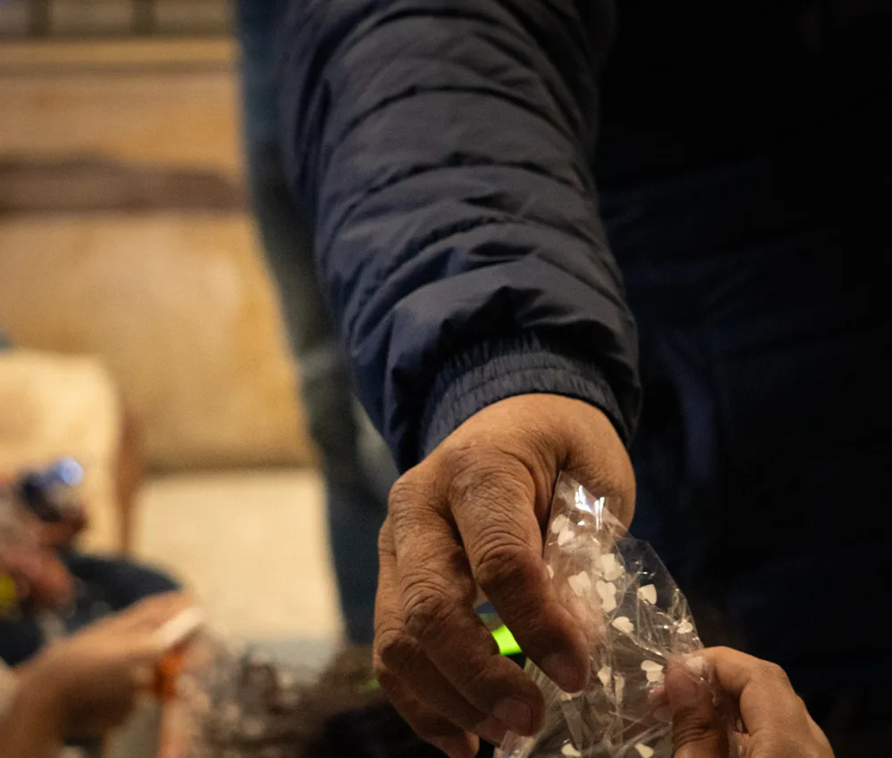 Una mano entrega una bolsita a otra durante una jornada de la fundación