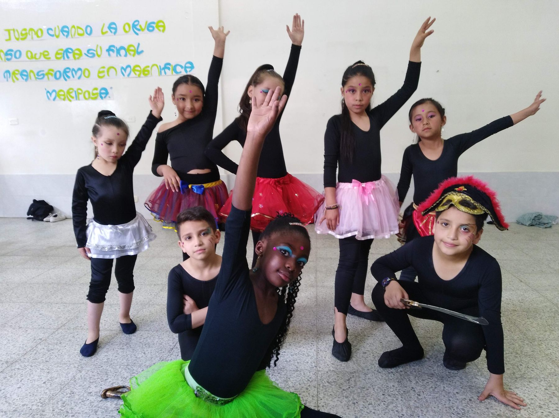 Niñas del semillero de danza posan bajo el mural de la mariposa