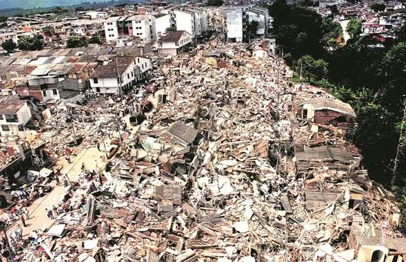 Vista aérea de casas destruidas y escombros en una ladera tras un terremoto