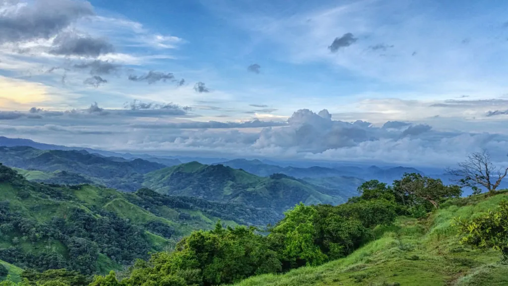 Montañas cubiertas de bosque verde bajo un cielo con nubes
