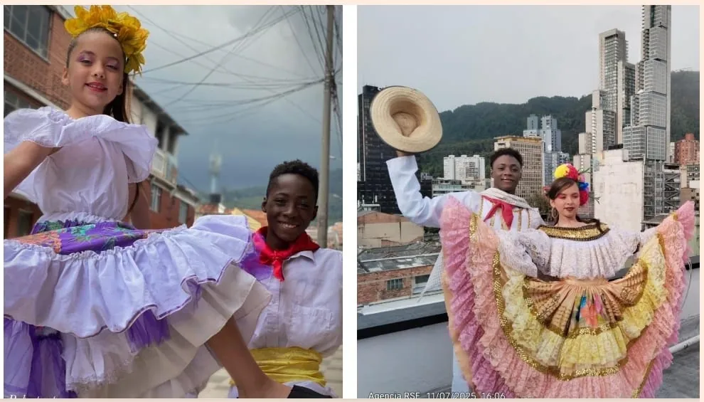 Dos jóvenes bailarines de la Escuela Cultural Morei con trajes típicos colombianos, en una terraza con los edificios de Bogotá al fondo
