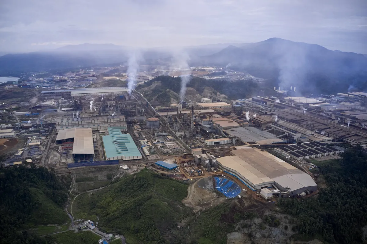 Vista aérea de una zona industrial con chimeneas humeantes entre montañas