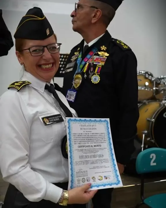 Rocío Agudelo Vargas, sonriente y con uniforme blanco, sostiene su Certificado al Mérito