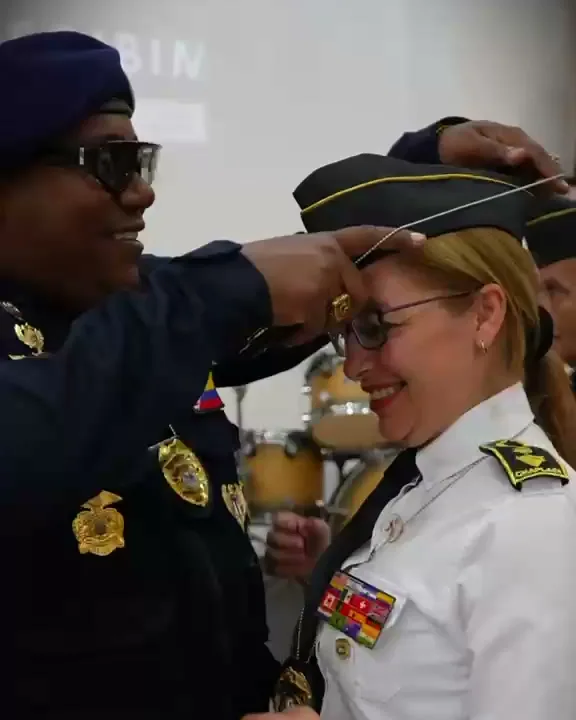 Le imponen la insignia en la gorra durante la ceremonia de certificación como capellana