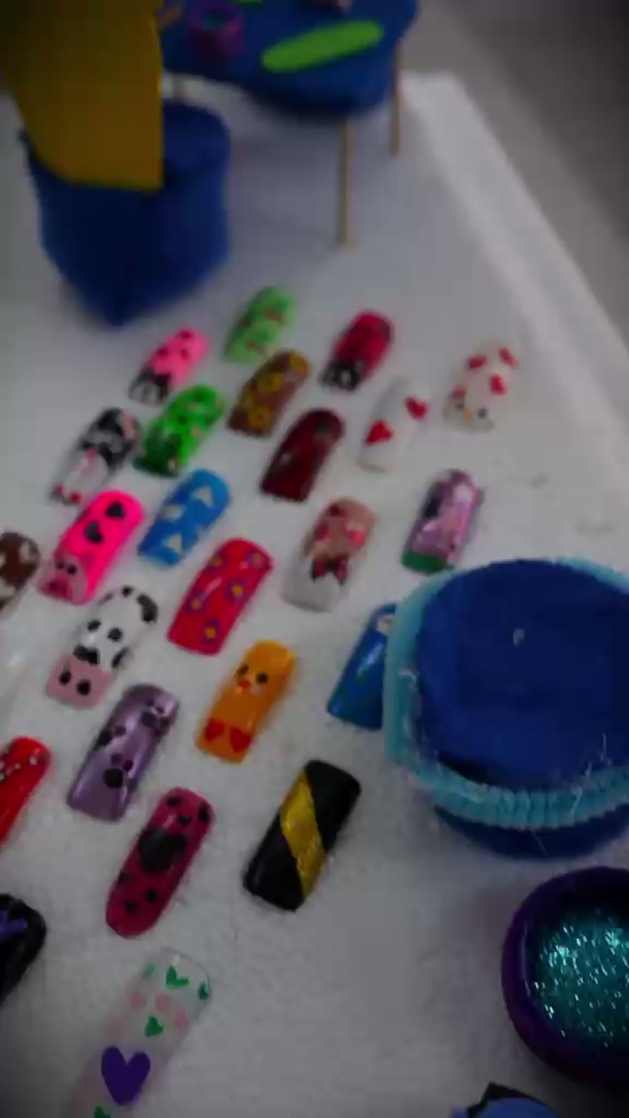 Tabla con uñas decoradas por las estudiantes del curso de estética de manos
